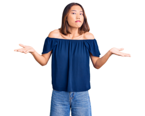 Young beautiful chinese girl wearing casual clothes clueless and confused expression with arms and hands raised. doubt concept.