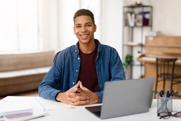 Cheerful black teen guy with laptop ready to learn