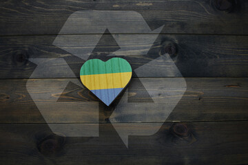 wooden heart with national flag of gabon near reduce, reuse and recycle sing on the wooden...