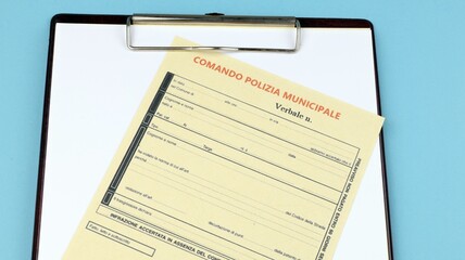 Verbal fine for traffic infringement "Italian Municipal Police" sheet on the desk.