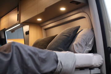 Interior design of a bedroom in a camper on wheels. Caravan, motorhome. Mobile home. Furniture