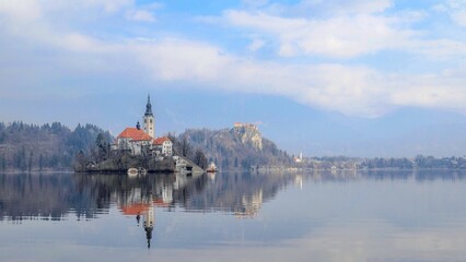 Scenic view of the Church of Mother of God on blue cloudy sky background on Lake Bled in Slovenia