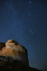 Beautiful view of a huge rock with the background of the starry sky at night in Jordan