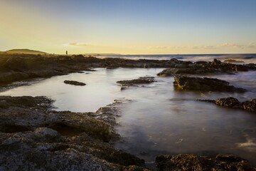 Sunset sky over the rocky beach in summer