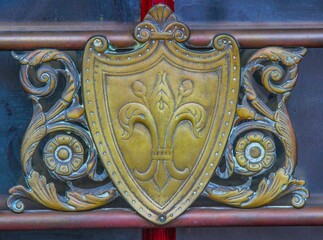 Closeup shot of a golden crest emblem ornament decorating the entrance of a building