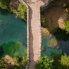 Aerial drone view of a bridge over a clean river on a sunny day