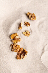 Walnut kernels on the sand. Vertical