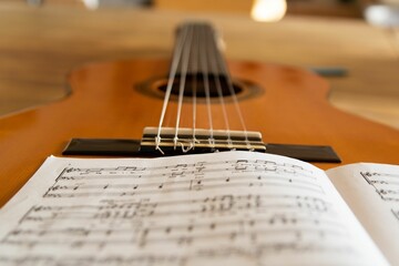 Closeup shot of a brown guitar with music notes