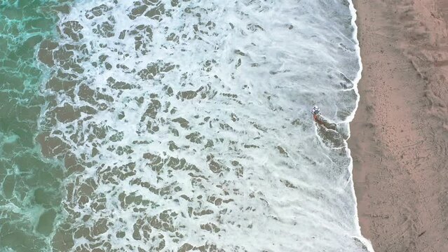 Aerial footage of a man walking on Punta Mita beach in Jalisco, Mexico