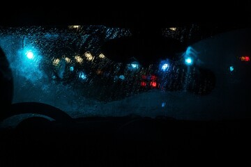 Nighttime view of a rainy blurry street from a driver's point of view