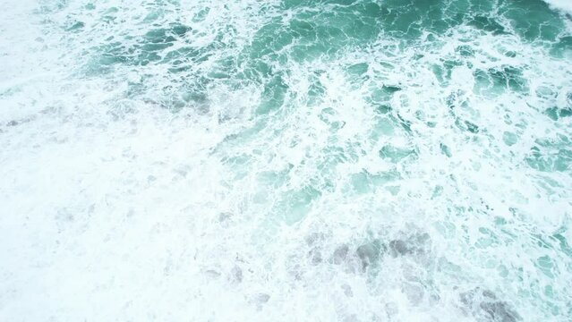 Closeup of a foamy sea waves splashing onto a sandy seashore