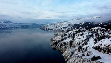 Aerial shot of a sea with rocky mountains in the shore in winter