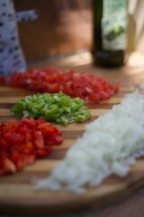 Heap of minced peppers and onions on a wooden board