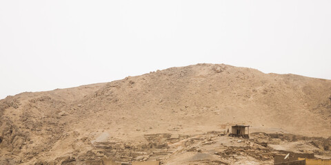 Dry desert hill and an abandoned building