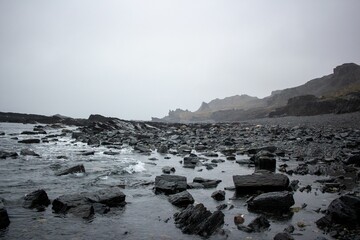 Stone coast by a river with stones under misty sky on the horizon in Murmansk