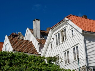 Low-angle view of beautiful suburban houses with white exteriors seen on a sunny day