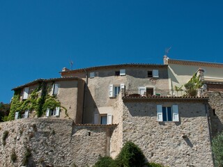 Fototapeta na wymiar Exterior of trees under stone traditional houses with blue sky in Le Castellet, France