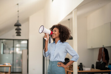 African american woman wearing blue shirt shouting loud holding a megaphone, expressing success and positive concept, idea for marketing or sales - obrazy, fototapety, plakaty
