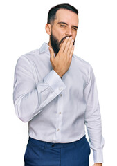 Young man with beard wearing business shirt bored yawning tired covering mouth with hand. restless and sleepiness.