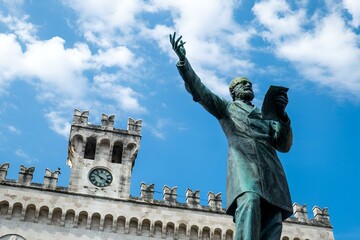 Man statue in front of a clock-adorned building: Chiavari, Italy