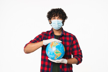 Young Indian man holding Globe expressing pandemic in mask against coronavirus isolated over white...