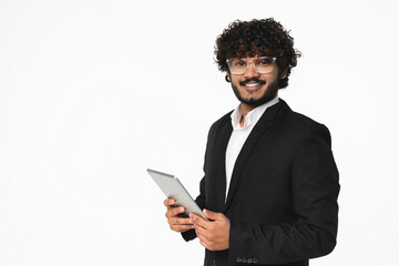 Smiley young Indian manager in suit using digital tablet for online shopping, remote work isolated over white background. Indian businessman sales manager bank employee doing e-commerce