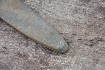 sharpening stone on wooden background close up