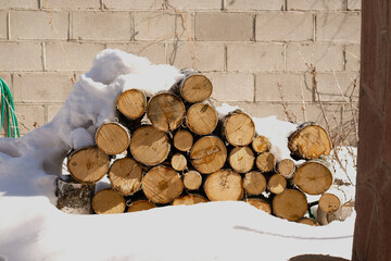 Stock of birch firewood under the snow