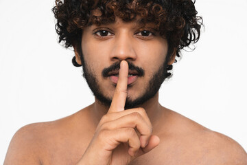 Top secret concept. Hindu young naked man gesturing finger on lips isolated over white background....