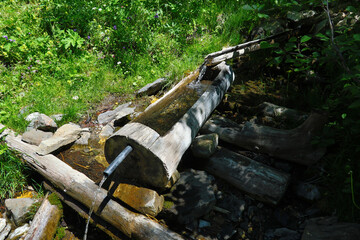Water recovery in the mountains through wooden pipes. - 775059311