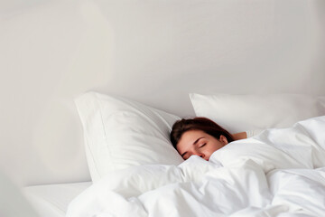 A woman peacefully sleeping in a bed with white sheets