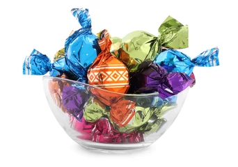Fototapeten Bowl with sweet candies in colorful wrappers on white background © New Africa