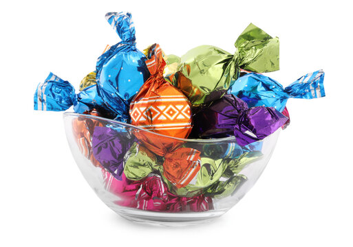 Bowl with sweet candies in colorful wrappers on white background