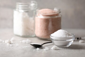 Fototapeta na wymiar Different natural salt on grey table, closeup