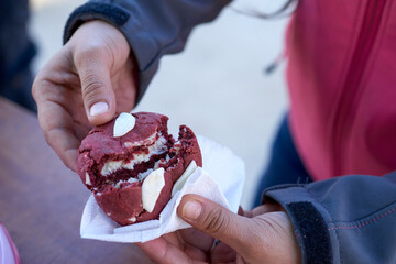 A close-up image capturing the moment a person holds a large, freshly baked berry cookie,...