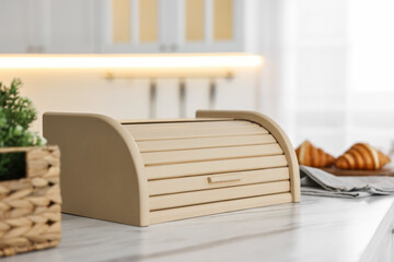 Wooden bread box on white marble table in kitchen