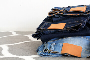 A pile of blue jeans on a chair