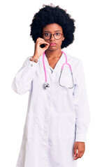 Young african american woman wearing doctor coat and stethoscope mouth and lips shut as zip with...
