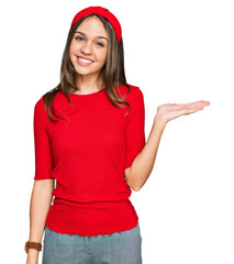 Obraz na płótnie Canvas Young brunette woman wearing casual clothes smiling cheerful presenting and pointing with palm of hand looking at the camera.