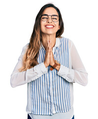 Beautiful hispanic woman wearing casual striped shirt praying with hands together asking for forgiveness smiling confident.