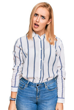 Beautiful caucasian woman wearing casual clothes in shock face, looking skeptical and sarcastic, surprised with open mouth