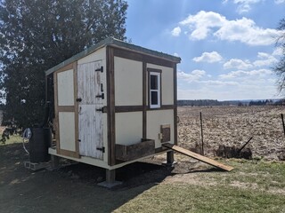 A white Chicken Coop on a sunny spring day