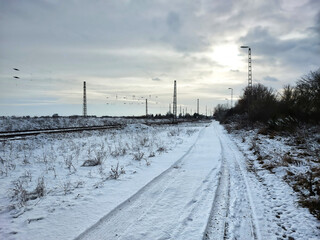 Railroad tracks and road in winterly Germany - 775082312
