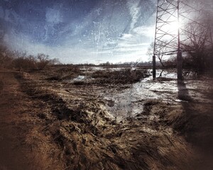 Grungy shot of recently flooded natural area with power lines
