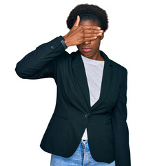 Young african american girl wearing business clothes covering eyes with hand, looking serious and...