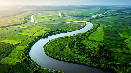 An aerial view of a winding river snaking through a patchwork of agricultural fields - obrazy, fototapety, plakaty