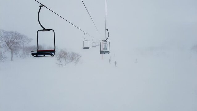 Niseko, Japan: Chairlift in the on a snowy cold day in the famous Niseko ski resort in Hokkaido in winter in northern Japan