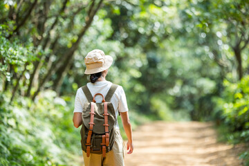 Active woman go hiking and walk along the trail in forest