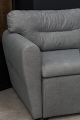 Gray soft sofa in the interior against a gray wall