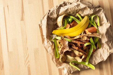 Food organic waste on eco friendly parchment paper, fruit and vegetable peel, garbage sorting and recycling